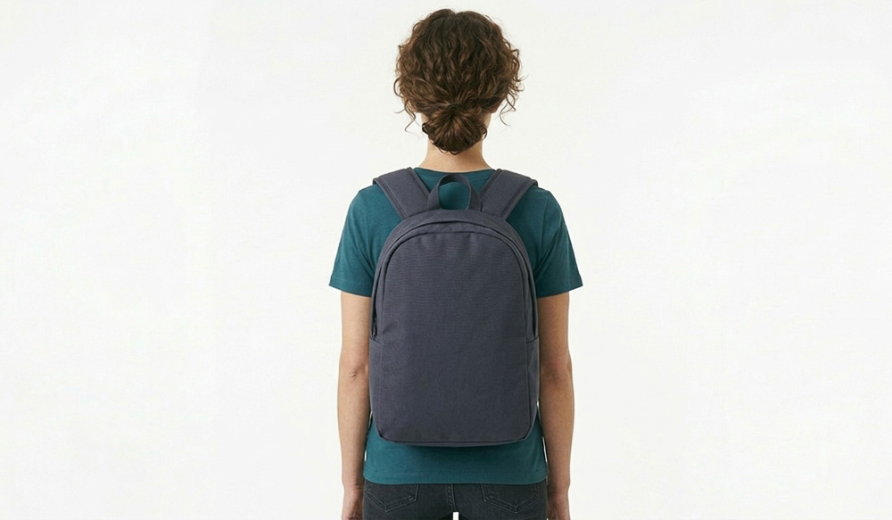 A woman wearing a blank grey backpack